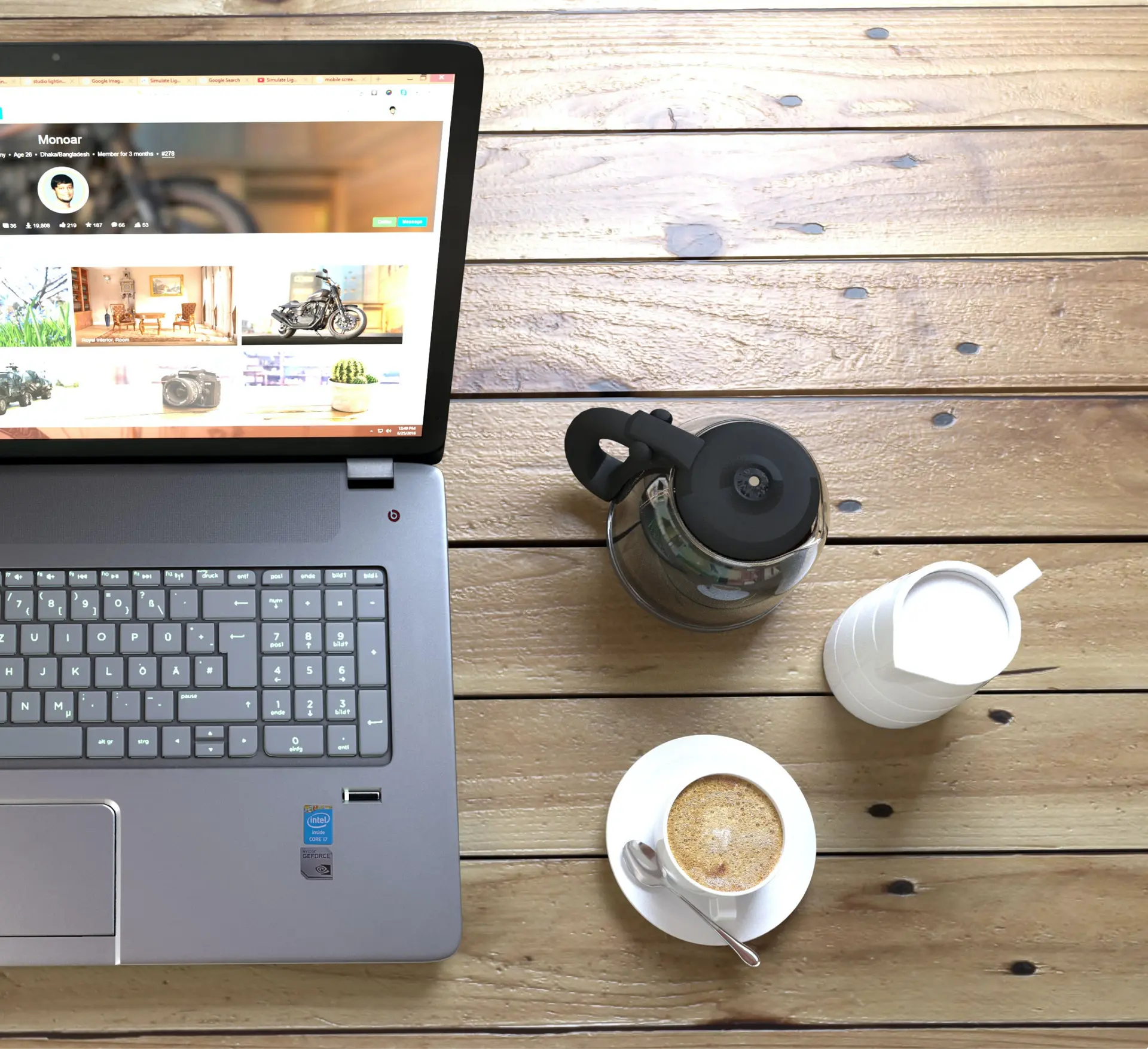 A top down photo of a laptop with coffee next to it.